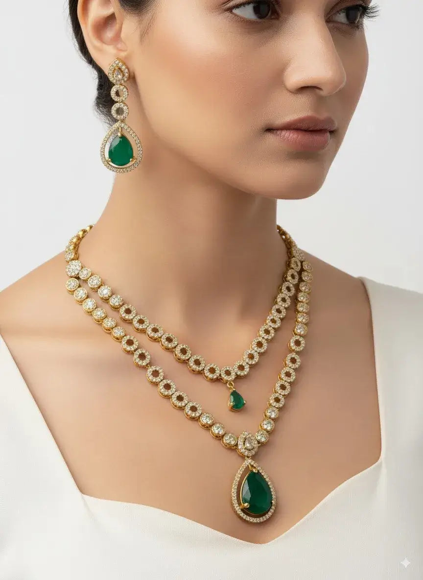 woman wearing a gold necklace with green gemstones and matching earrings on a white background