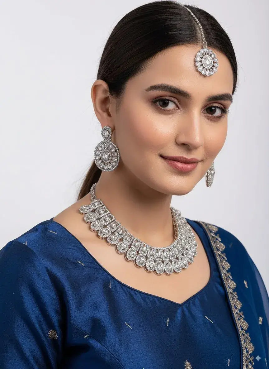 cz diamond bridal choker necklace set with earrings & maang tikka worn by a model in a blue outfit.