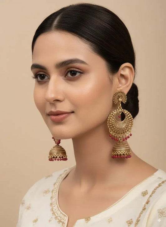 Gold Plated Jhumka Earrings with Red Beads | Ethnic Indian Jewelry for Women worn by a model in traditional attire.