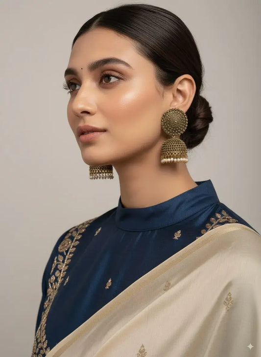 Antique Gold Oversized Dome Stud Jhumka Earrings with Pearl Drops worn by a model in traditional attire.