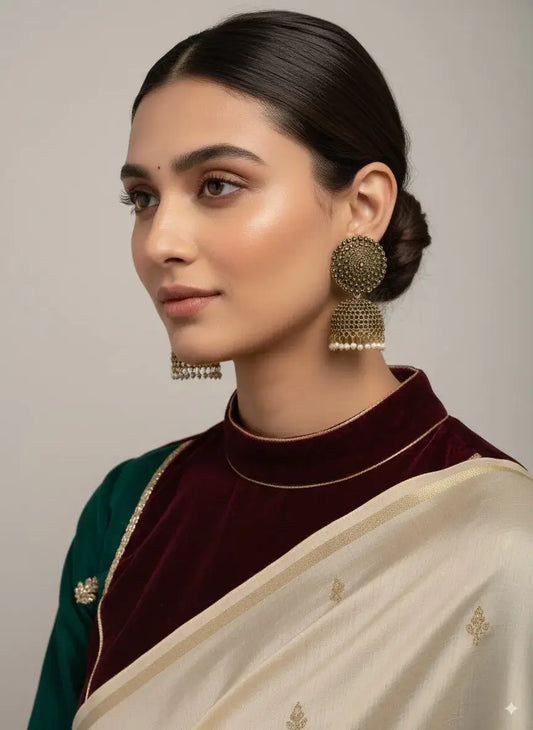 Antique Gold Oversized Dome Stud Jhumka Earrings with Pearl Drops worn by a model in traditional attire.