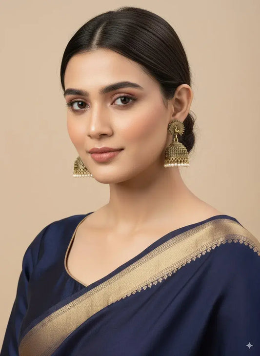 Antique Gold Peacock Jhumka Earrings with Pearl Drops – Traditional Jewellery worn by a model.