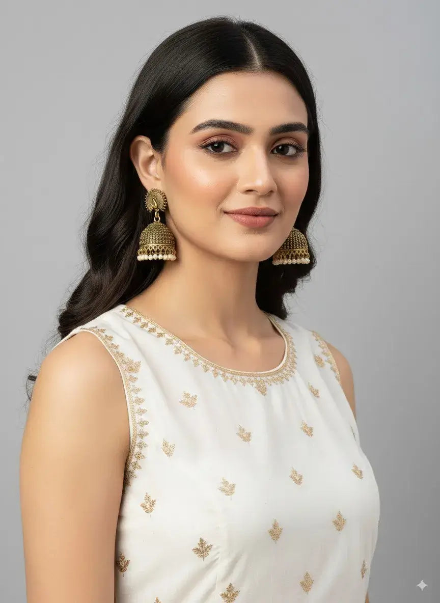 antique gold peacock jhumka earrings with pearl drops – traditional jewellery worn by a model.