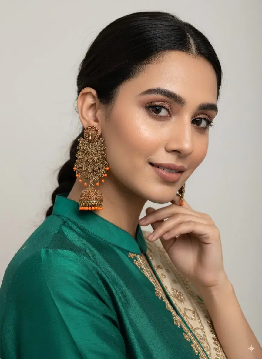 gold plated long jhumka earrings with orange beads – ethnic & bridal jewellery worn by a model.
