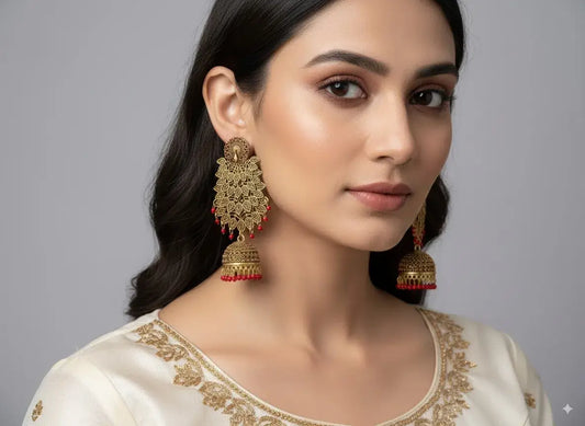 Gold Plated Long Jhumka Earrings with Red Beads – Bridal & Ethnic Wear worn by a model, showcasing elegance and traditional style.